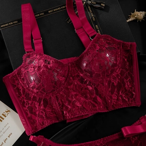 Detailed view of a dark red lace corset top with adjustable straps on a black silk background