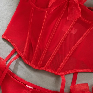 Macro detail of red boned corset with mesh bow and sheer lace texture details