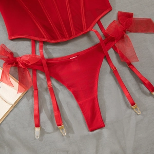 Detail of red mesh corset lingerie set with satin bows and garter belt system