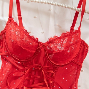 Detail of red lace lingerie with sparkling rhinestones and delicate bow on satin strap