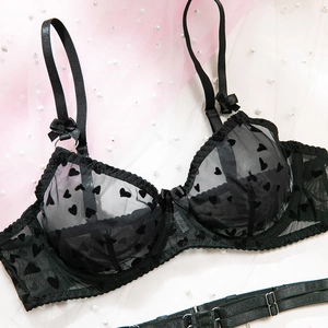 Gros plan sur un soutien-gorge en maille noire avec motifs cœurs floqués et dentelle fine