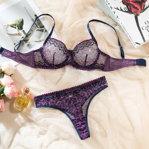 Detail of purple leopard print lace lingerie set with silk straps on satin background