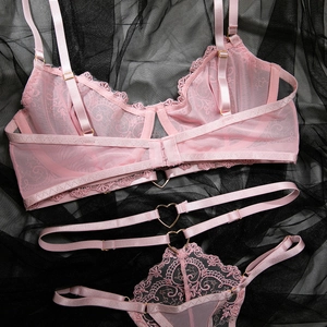Gros plan sur la dentelle florale rose et les boucles en cœur de cet ensemble lingerie