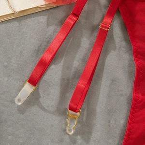 Detail view of red mesh fabric with adjustable garter straps and gold metal clips