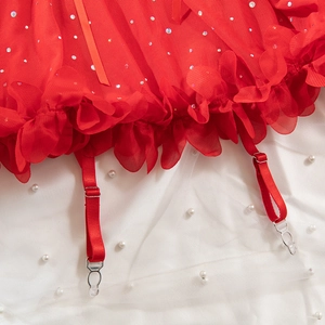 Detail of red sequined mesh dress with lace trim and adjustable garter straps