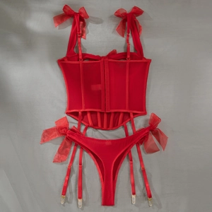 Macro detail of red corset with mesh paneling, bow straps, and garter attachment clips