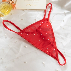 Detail of red mesh T-back thong with sparkling rhinestones on white silk background