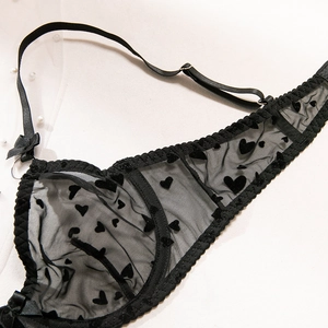Détail de lingerie sexy en tulle noir avec motifs cœurs et nœuds décoratifs
