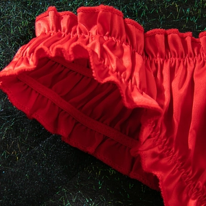Macro shot of red satin bra set showing ruffled edges and pleated texture details
