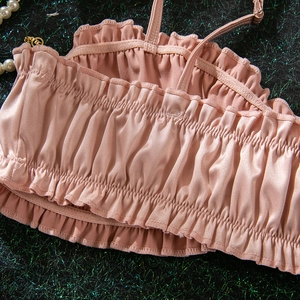 Close-up of pink satin camisole featuring intricate pleated texture and ruffles