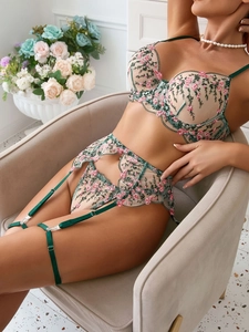 Macro shot of delicate floral embroidery on sheer mesh lingerie with fine lace textures
