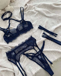 Detail of navy blue lace lingerie set with cross-strap design and gold metal buckles