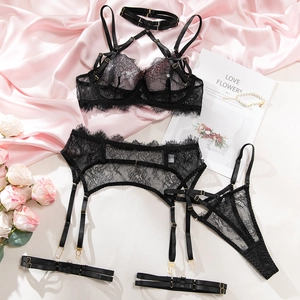 Flat lay of black lace lingerie set with eyelash lace and gold metal hardware
