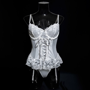 Close-up of white lace corset dress with ribbon lace-up and floral mesh details