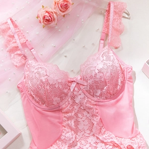 Close-up of pink lace bodysuit featuring floral embroidery and satin bow detail