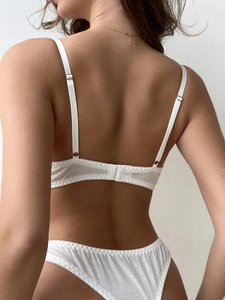 Back view of a white ribbed cotton lingerie set featuring adjustable straps and a clasp