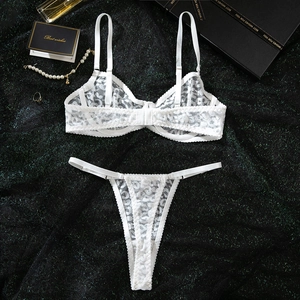 Detailed view of a white leopard lace lingerie set with underwire bra and thong on a gift box