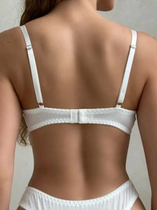 Detailed back view of white ribbed cotton lingerie set showing adjustable straps and hook closure