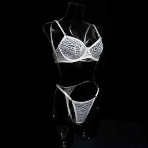 Detailed view of white floral lace lingerie set with underwire support on dark background