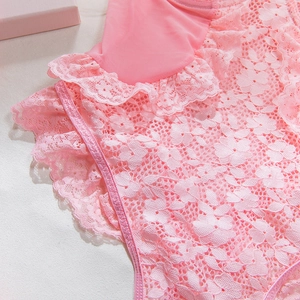 Detailed macro view of pink lace fabric with floral patterns and ruffled mesh textures