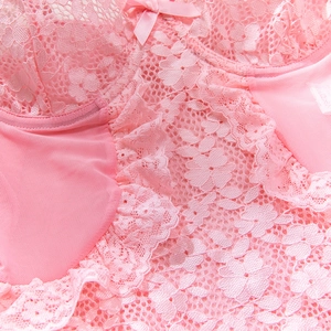 Detail view of pink floral lace bodysuit featuring a satin bow and mesh texture