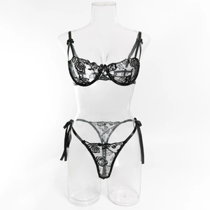 Dettaglio di ricamo a rose nere e fiocchi di raso su questo set di lingerie in pizzo