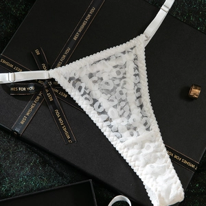 Detail of white lace thong with leopard texture in a luxury black gift box with ribbon