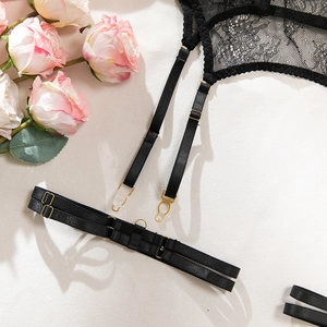 Detailed view of black floral lace garter belt with elegant gold metal adjustment buckles