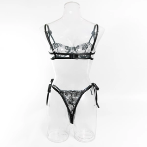 Dettaglio del set lingerie in pizzo nero con ricamo a rose e fiocchi sui lati del perizoma