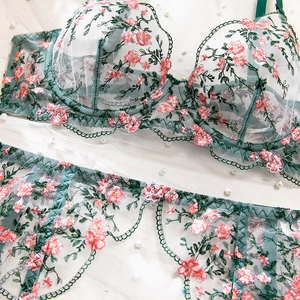 Detail of floral embroidery on sheer mesh lingerie set with lace trim and pearls