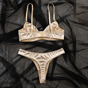 Vista dettagliata del set reggiseno e perizoma in raso champagne su tulle nero