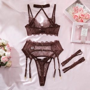 Detailed flat lay of a 4-piece brown lace lingerie set with garters on pink satin