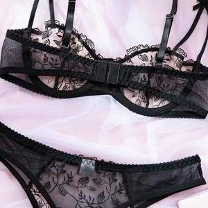 Detail of floral embroidery on black lace bra and panty set with sheer mesh fabric