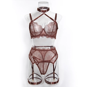 Detail showing lace texture and metallic hardware of the four-piece lingerie set