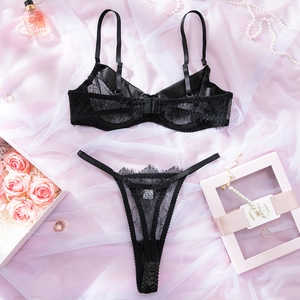 Detailansicht eines schwarzen Spitzen-Lingerie-Sets auf Satin mit Perlen und Rosen