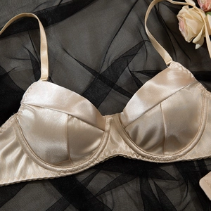 Dettaglio del reggiseno in raso champagne con coppe a pieghe e ferretto di supporto