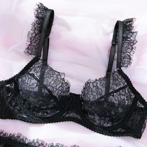 Dettaglio di lingerie in pizzo nero con ferretto e bordi floreali in mesh trasparente