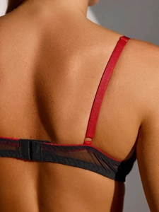 Detail of red adjustable straps and black lace mesh back with hook closure for lingerie