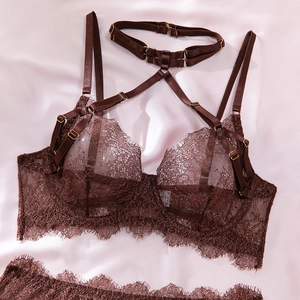 Close-up of deep brown eyelash lace details and gold hardware on four-piece lingerie set