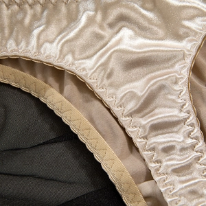 Dettaglio reggiseno in raso champagne con finitura lucida e bordo elastico smerlato
