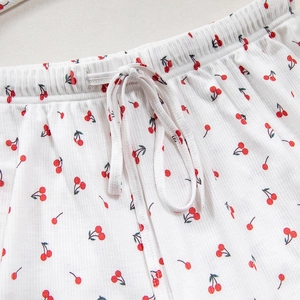 Dettaglio dei pantaloncini bianchi con ciliegie in maglia a costine e coulisse elastica