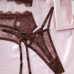Detailed close-up of dark brown eyelash lace fabric with gold adjustable buckles