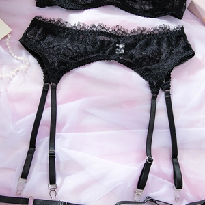 Dettaglio del reggicalze in pizzo nero con spalline regolabili e fibbie metalliche