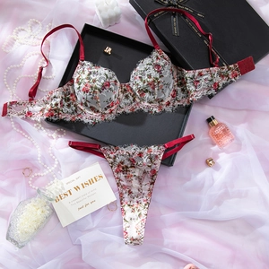 Détail à plat d'un ensemble de lingerie en dentelle florale rouge avec soutien-gorge et thong