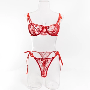Dettaglio del ricamo a rose rosse sul reggiseno in pizzo e fiocco decorativo