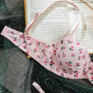 Detailed view of pink French style cherry print bra set with textured fabric surface