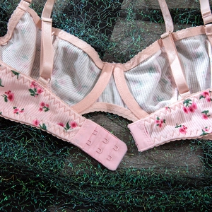 Close-up of pink floral bra showing the back closure and ribbed fabric texture