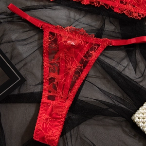 Detailaufnahme des roten Spitzen-Strings mit floraler Stickerei und Trägern