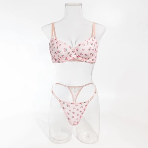 Detailed close-up of pink floral lingerie set with wired bra and thong on a clear mannequin