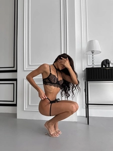 Détail d'un ensemble de lingerie en dentelle noire avec tour de cou et anneau de cuisse